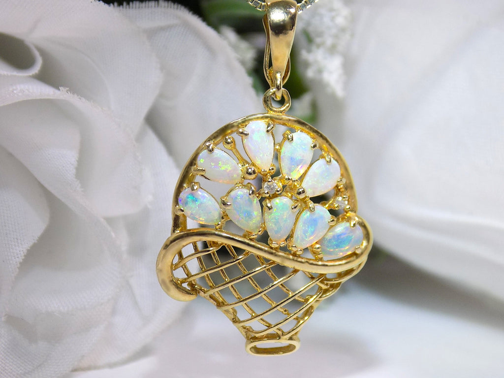 The is a genuine oval shape opal basket pendant in yellow gold from our estate collection in like new condition with white background.