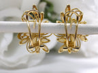 These are a pair of genuine marquise shape opal cluster earrings shown from the back highlighting the omega style backs in yellow gold shown on white flower background.