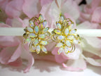 These are a pair of genuine marquise shape opal cluster earrings with omega backs in yellow gold on pink flower background.