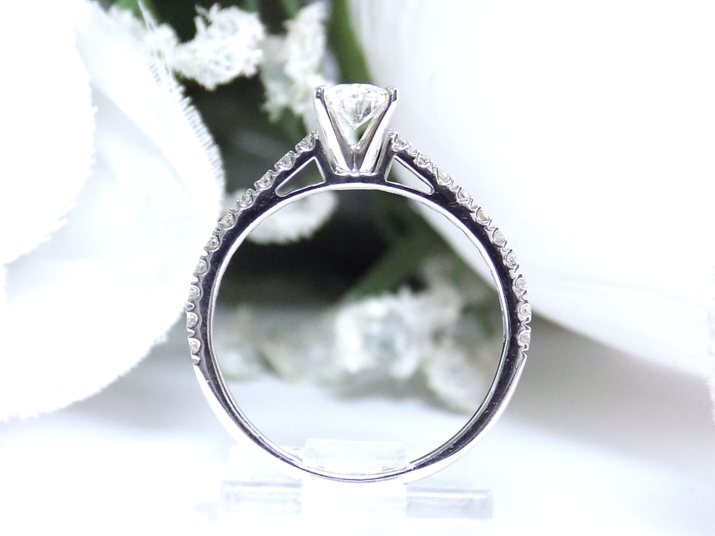 This is a side view of natural oval shape diamond engagement ring with a white background.