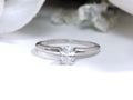 This is a white gold natural oval shape diamond solitaire with white background.