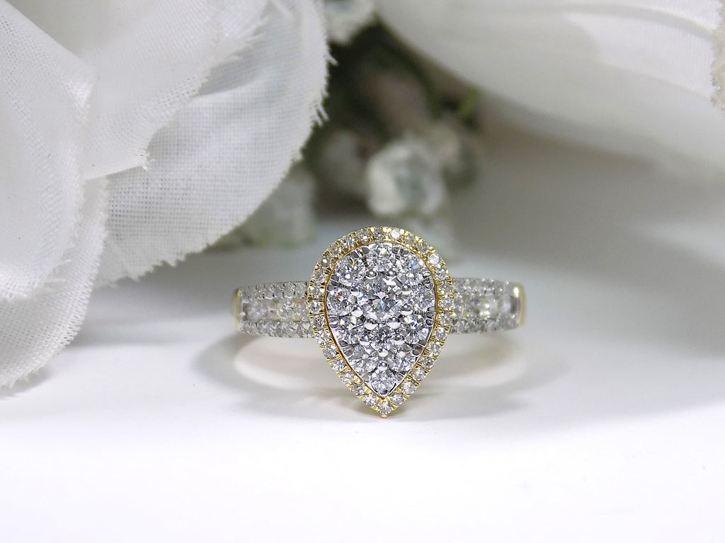 This is a .75ct total weight pear shape natural diamond cluster ring in two tone white and yellow gold on a white background.