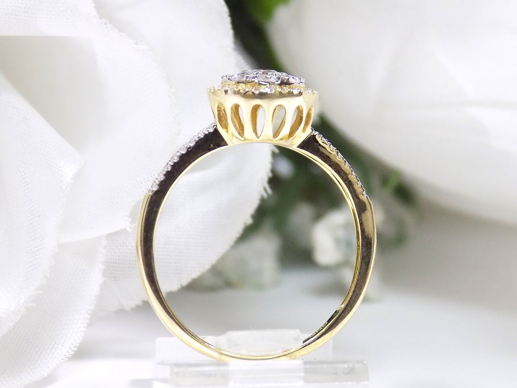 This is a .75ct total weight pear shape natural diamond cluster ring in two tone white and yellow gold side view.