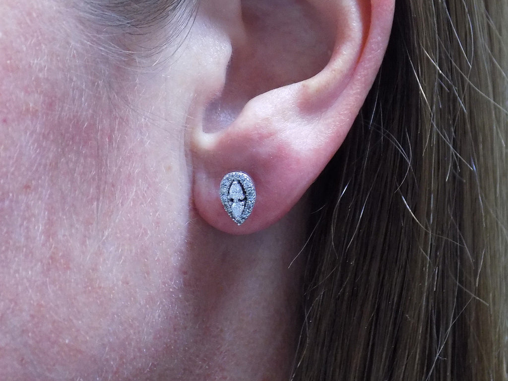 This is a pear shape .40ct total weight natural diamond cluster earrings in 10K white gold in a ladies ear.