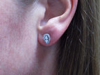 This is a pear shape .40ct total weight natural diamond cluster earrings in 10K white gold in a ladies ear.