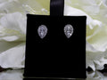 This is a pear shape .40ct total weight natural diamond cluster earrings in 10K white gold on a black earring pad with aa white floral background.