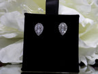 This is a pear shape .40ct total weight natural diamond cluster earrings in 10K white gold on a black earring pad with aa white floral background.