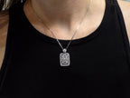 This is a Victorian style pendant with 1.00ct total weight round and baguette diamonds set in 900 platinum on a ladies neck with black shirt.
