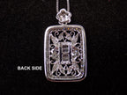 This is a Victorian style pendant with 1.00ct total weight round and baguette diamonds set in 900 platinum view of the back of the pendant on a black background.