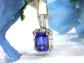 This is a women's 4.90ct natural high-end rectangular cushion cut tanzanite pendant surrounded by .75ct natural baguette and round diamond accents in 14K yellow gold with a floral background.