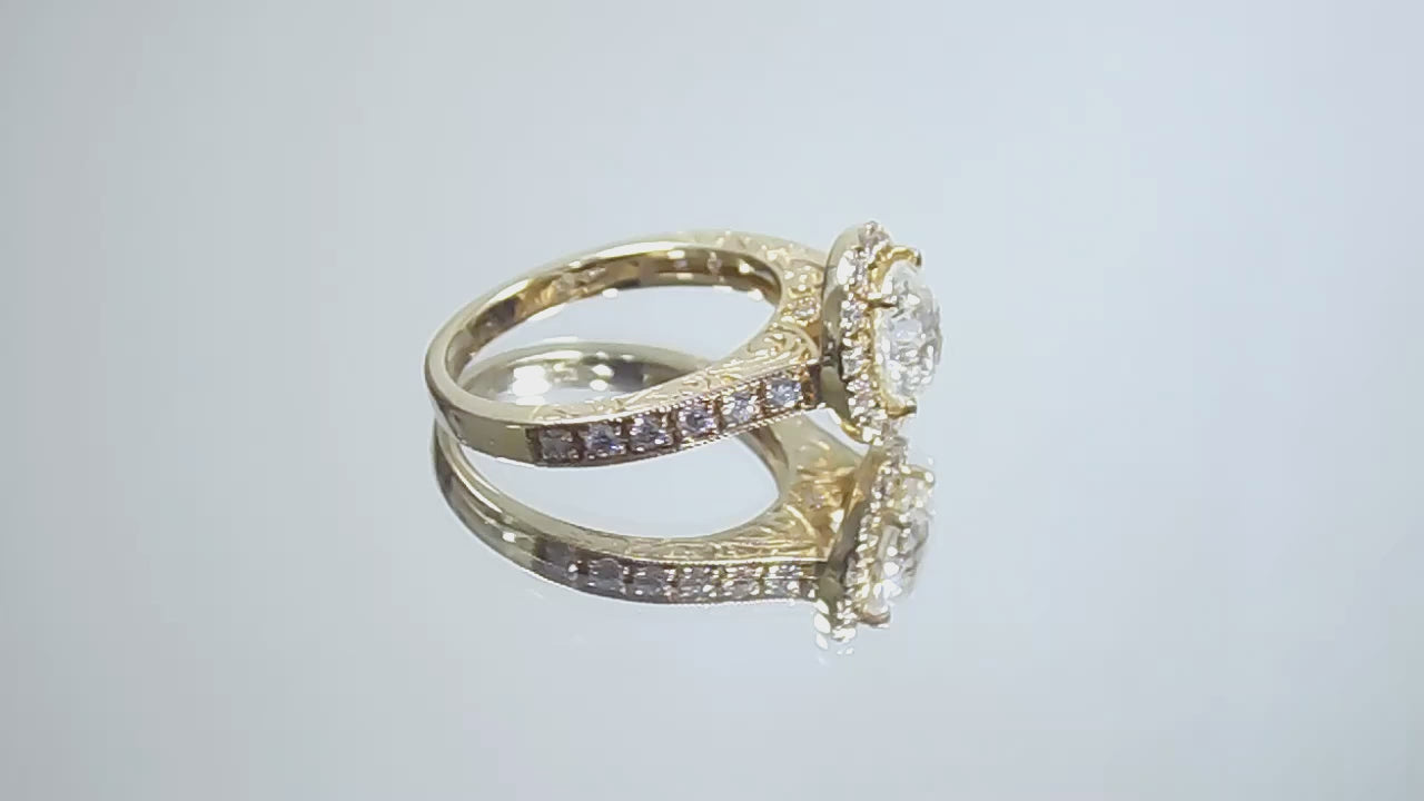 This is video of a halo style 2.17ct total weight natural round diamond ring with a 1.52ct center diamond in yellow gold shown turning slowly on a mirrored background.