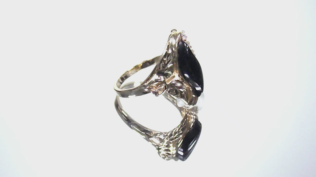This is a video of a genuine black onyx and diamond ring in yellow gold from our estate collection in like NEW condition shown rotating slowly on a mirrored background.