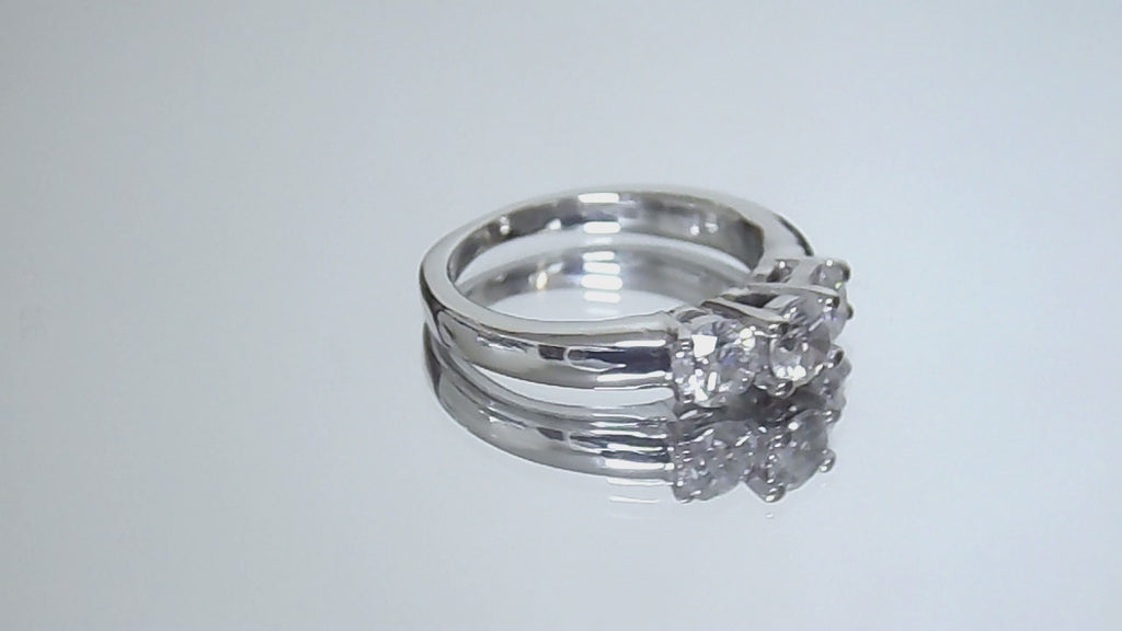 This is a video of a 3-stone style natural .90ct total weight round diamond ring in white gold turning slowly on a mirrored backgound.
