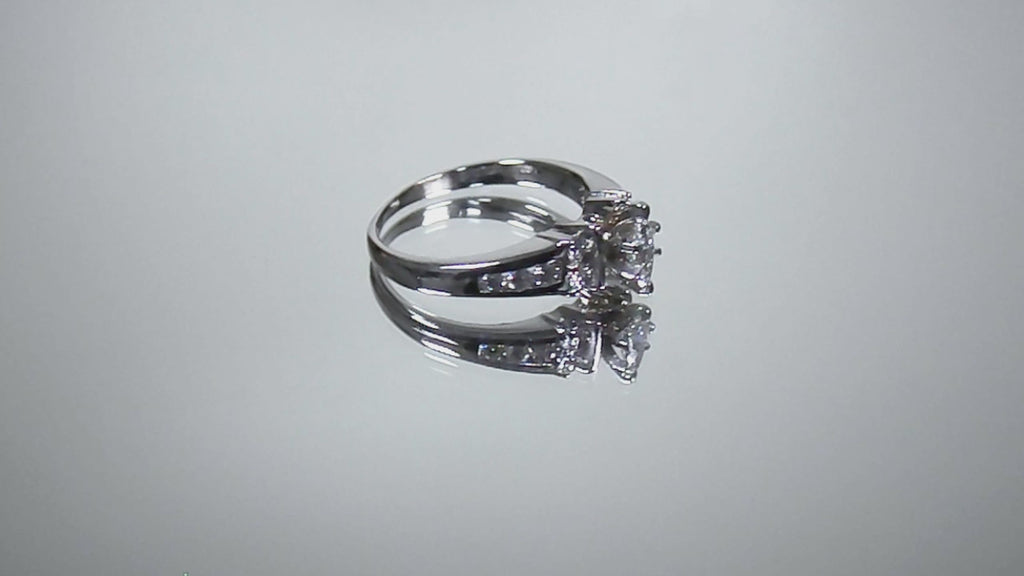 This is a marquise shape diamond ring with round diamond accents in white gold turning slowly on a mirrored background.