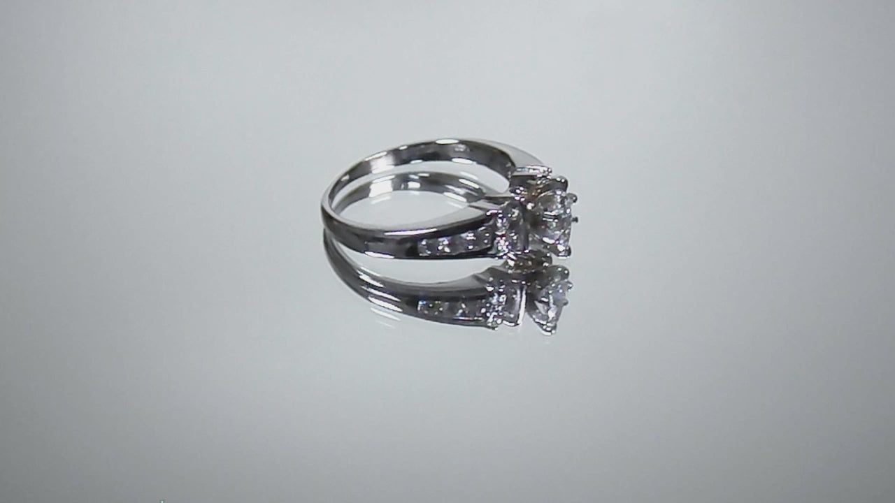 This is a marquise shape diamond ring with round diamond accents in white gold turning slowly on a mirrored background.