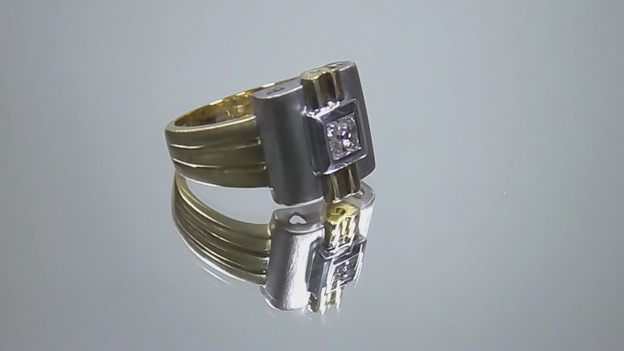 This is a woman's vintage art-deco ring that is two-tone with a brushed 18K yellow and white gold finish with .20ct total diamond weight rotating on a mirrored surface in a video