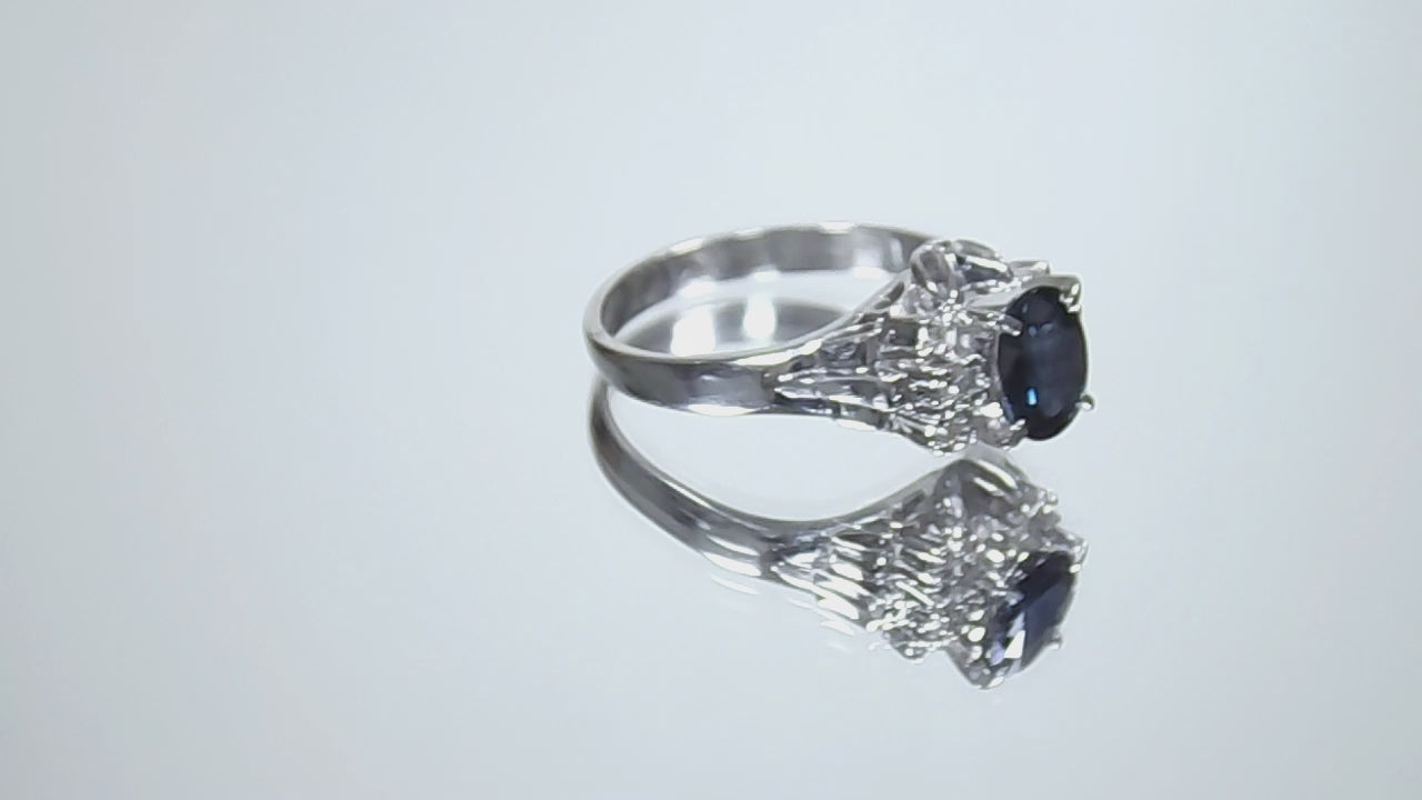 This is a video of a women's vintage pre-world war II genuine oval shape sapphire and natural diamond ring 1.36ct total weight in platinum restored to showcase condition shown rotating on a mirrored background.