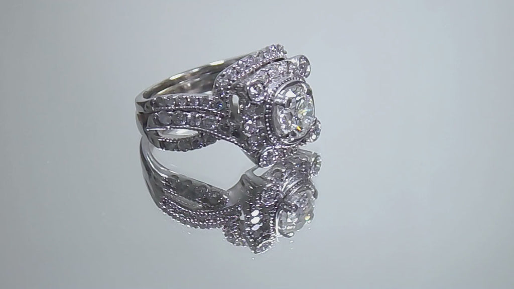The is video of a 1.95ct total weight natural 2-piece natural round diamond wedding set with engagement ring and matching band already tacked together from our estate collection in white gold shown turning slowly on a mirrored background. 