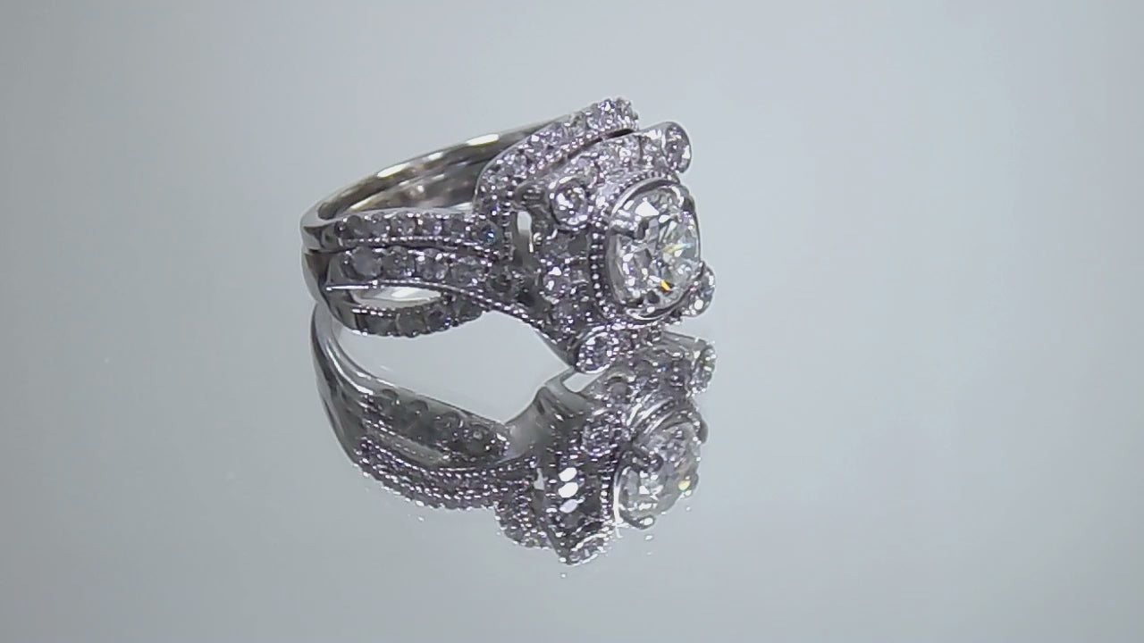 The is video of a 1.95ct total weight natural 2-piece natural round diamond wedding set with engagement ring and matching band already tacked together from our estate collection in white gold shown turning slowly on a mirrored background. 
