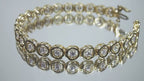 This is a 2.00ct total weight diamond bracelet in 14K yellow gold on a mirrored background rotating in a video.