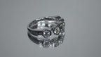 This is a 5 stone bezel set natural round diamond band in 14K white gold rotating in a video on a mirrored background.