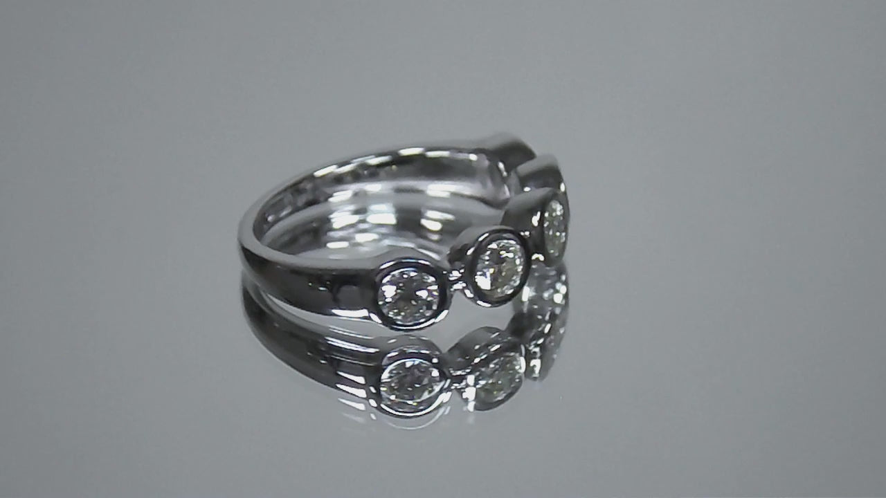 This is a 5 stone bezel set natural round diamond band in 14K white gold rotating in a video on a mirrored background.