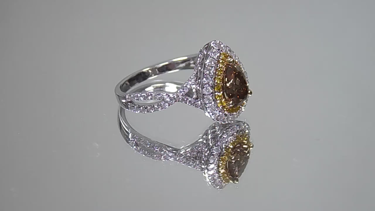 This is a video of a 1.69ct total weight genuine natural pear shape chocolate diamond ring with canary yellow and white diamond accents in white gold shown rotating slowly on a mirrored background.
