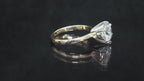 This is a video of a 2.20ct natural round brilliant diamond solitaire in yellow gold turning slowly on a black mirrored background.