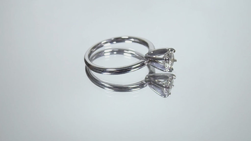 The is video of a natural .60ct round brilliant diamond solitaire engagement ring in white gold shown turning slowly on mirrored background.