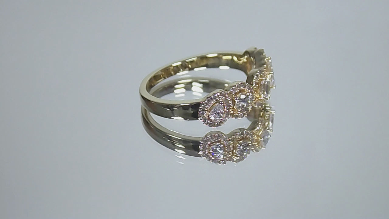 This is a multi shape natural diamond ring including a pea shape, round brilliant, emerald cut, princess cut and oval shape all surrounded by round diamond accents in 10K yellow gold rotating on a mirrored surface in a video.