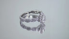 This is a video of a halo style .82ct total weight natural pear shape diamond ring with infinity style band in white gold shown turning slowly with a mirrored background.