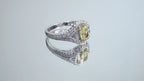 This is a video of a 1.35ct total weight natural fancy yellow not enhanced diamond ring with white diamond accents in white gold shown turning slowly on a mirrored background.