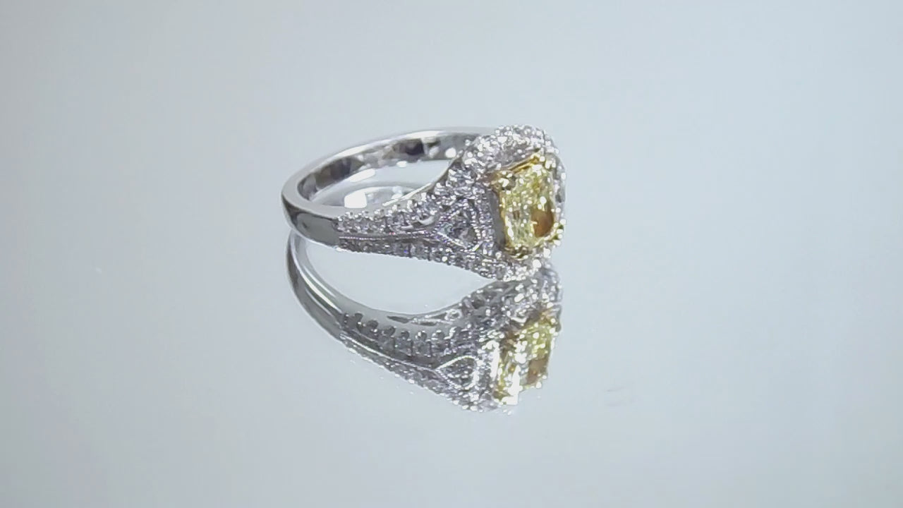 This is a video of a 1.35ct total weight natural fancy yellow not enhanced diamond ring with white diamond accents in white gold shown turning slowly on a mirrored background.