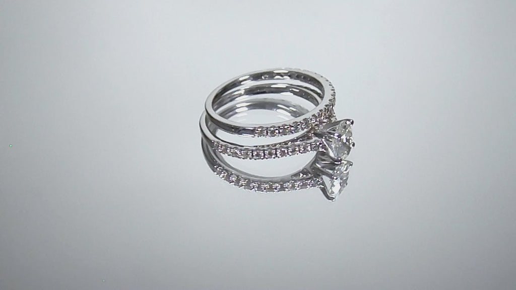 This is a video of a natural oval shape diamond wedding set ring with matching band in white gold shown turning slowly on a mirrored backgound.