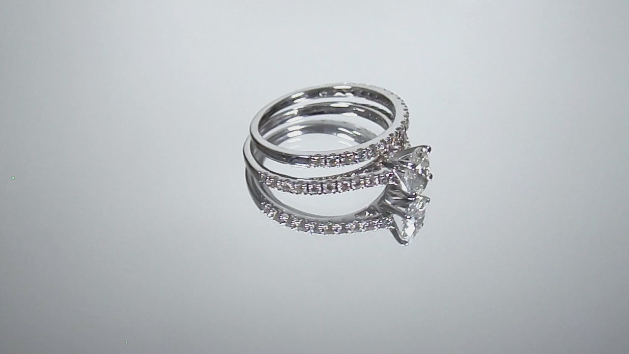 This is a video of a natural oval shape diamond wedding set ring with matching band in white gold shown turning slowly on a mirrored backgound.