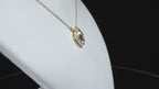 This is a .25ct natural center marquise diamond necklace with a halo of .10ct round diamonds in 14K yellow gold in a rotating video on a white display neck.