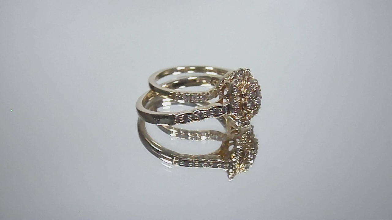 This is a video of a 2-Piece yellow gold and diamond wedding set ring with matching band turning slowly with mirrored background.
