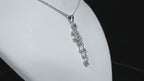This is a custom made .91ct natural baguette diamond necklace in 18K white gold rotating on a white neck in a video.