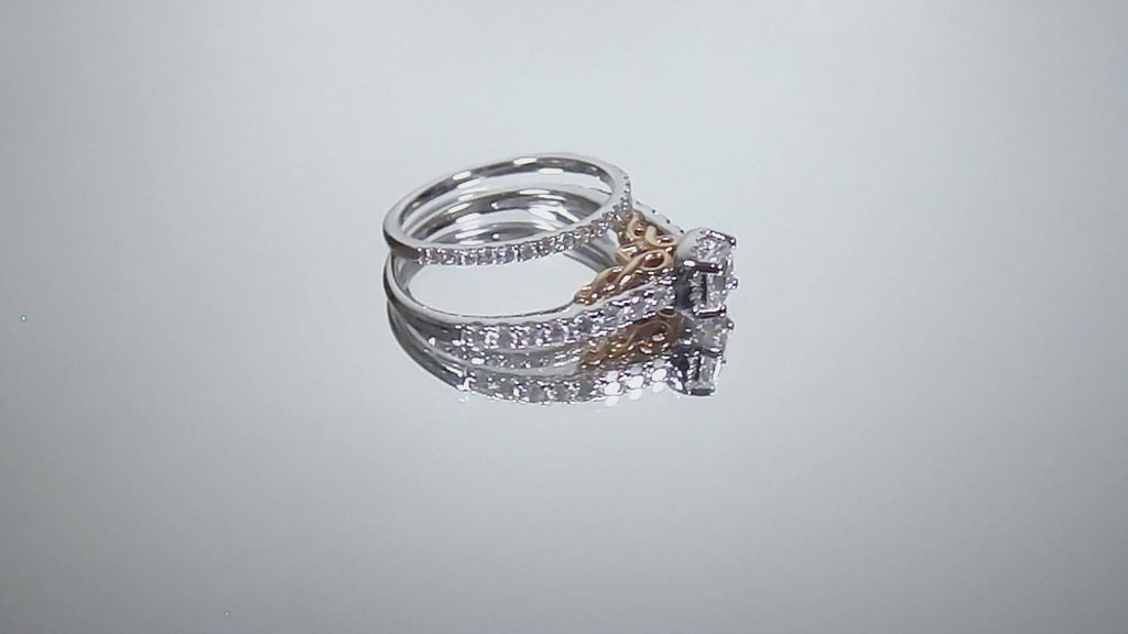 This is a video of halo style women's 2-piece wedding set including the engagement ring and matching band with princess cut center weighing .88ct total in white gold with rose accents shown rotating on mirrored background.