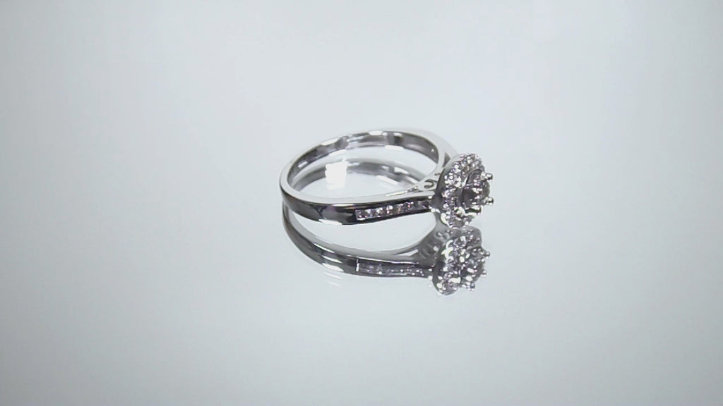 This is a video of a ladies' halo style small round diamond ring in white gold turning slowly on mirrored background.
