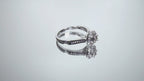 This is a video of a ladies' halo style small round diamond ring in white gold turning slowly on mirrored background.