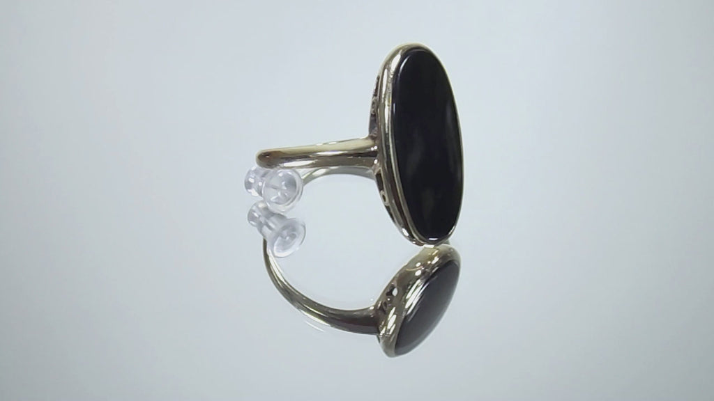 This is a vintage oval bezel set black onyx ring in 10K yellow gold.  It is 21mm long and 18mm wide on a mirrored surface rotating in a video.