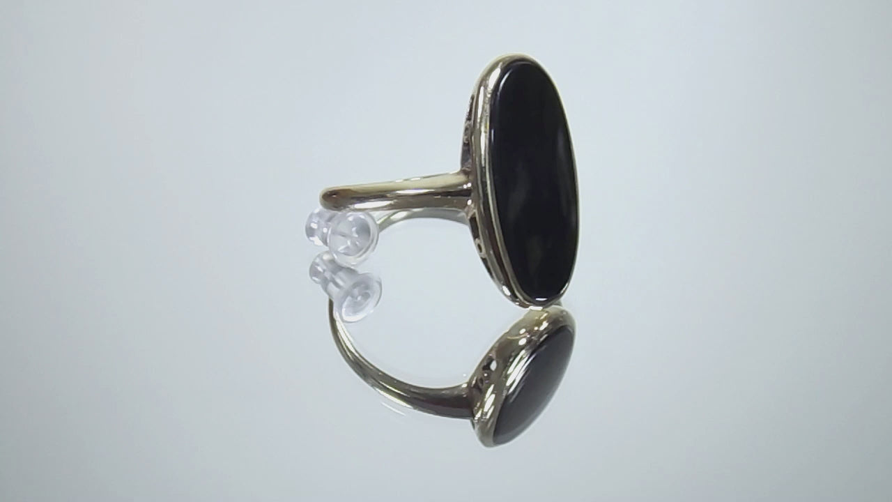 This is a vintage oval bezel set black onyx ring in 10K yellow gold.  It is 21mm long and 18mm wide on a mirrored surface rotating in a video.