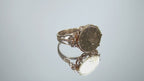 This is a video of a women's US $1 gold coin ring dated 1853 and set in 14K yellow gold in great condition shown rotating on mirrored background.