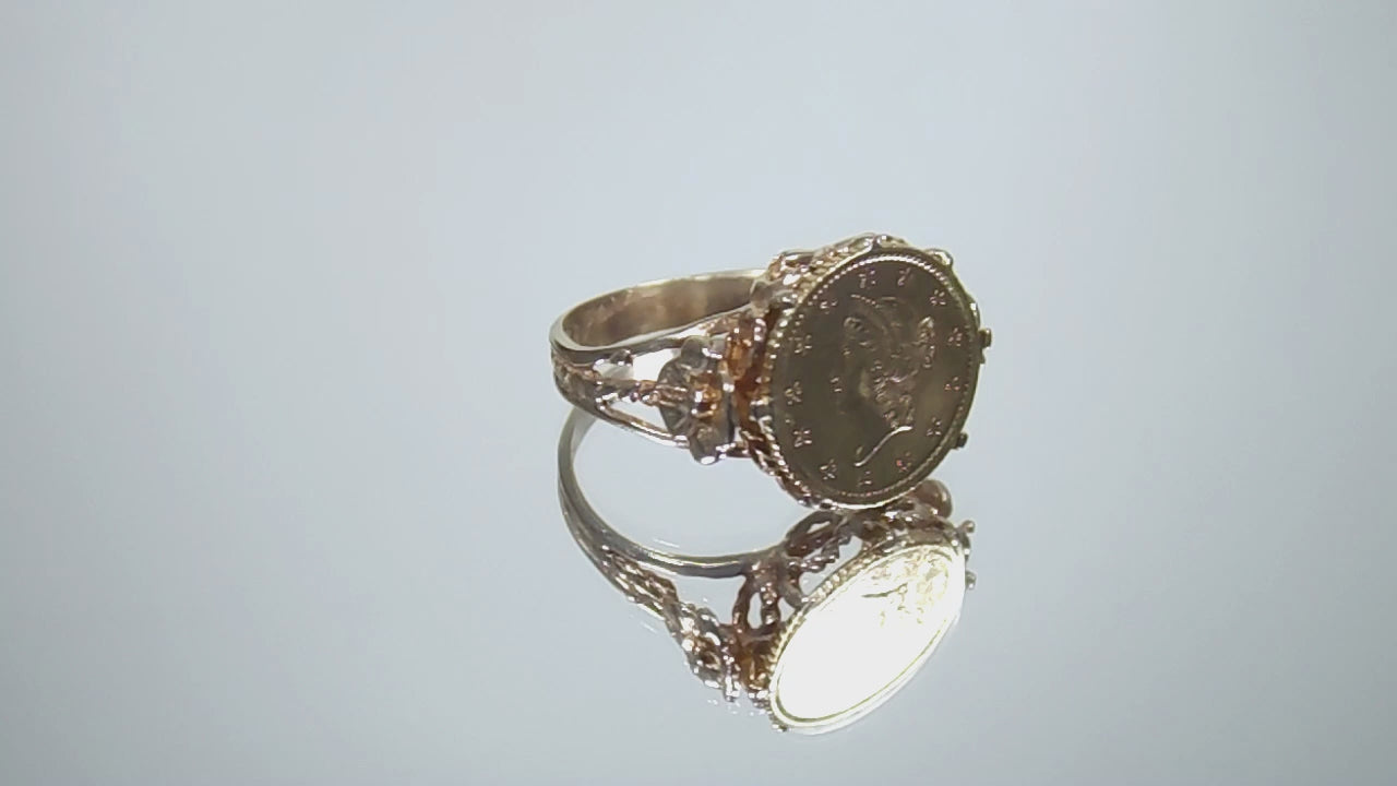 This is a video of a women's US $1 gold coin ring dated 1853 and set in 14K yellow gold in great condition shown rotating on mirrored background.