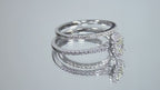 This is a video of a .73ct total weight 2-piece halo style oval shape natural diamond wedding set with engagement ring and matching band shown turning slowly on a mirrored background.