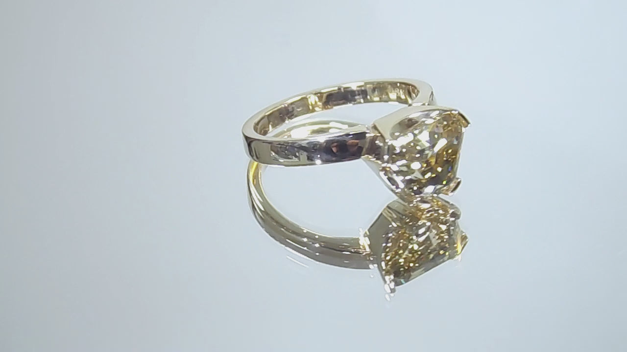 This is a video of a 3.06ct natural GIA certified custom shield cut fancy chocolate diamond solitaire ring in yellow gold turning slowly on a mirrored background.
