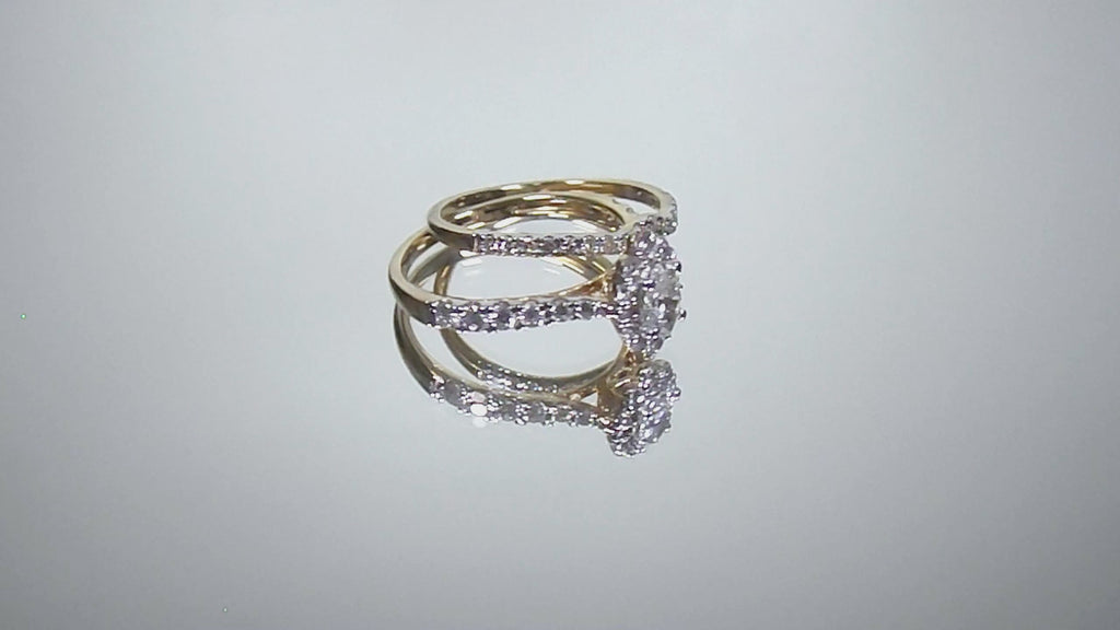 This is a video of a 2-piece natural oval shape diamond wedding set weighing 1ct total with both the engagement ring and matching band in yellow gold with white gold prongs shown turning slowly on a mirrored backgrouond.