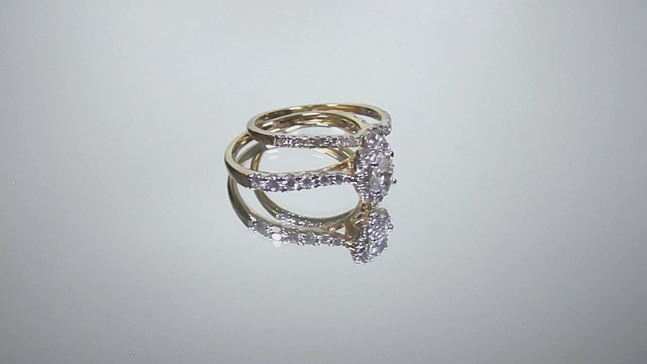 This is a video of a 2-piece natural oval shape diamond wedding set weighing 1ct total with both the engagement ring and matching band in yellow gold with white gold prongs shown turning slowly on a mirrored backgrouond.