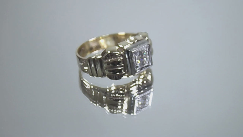 This is a video of an antique natural diamond ring from the turn of the century in yellow and white gold shown turning slowly on a mirrored background.